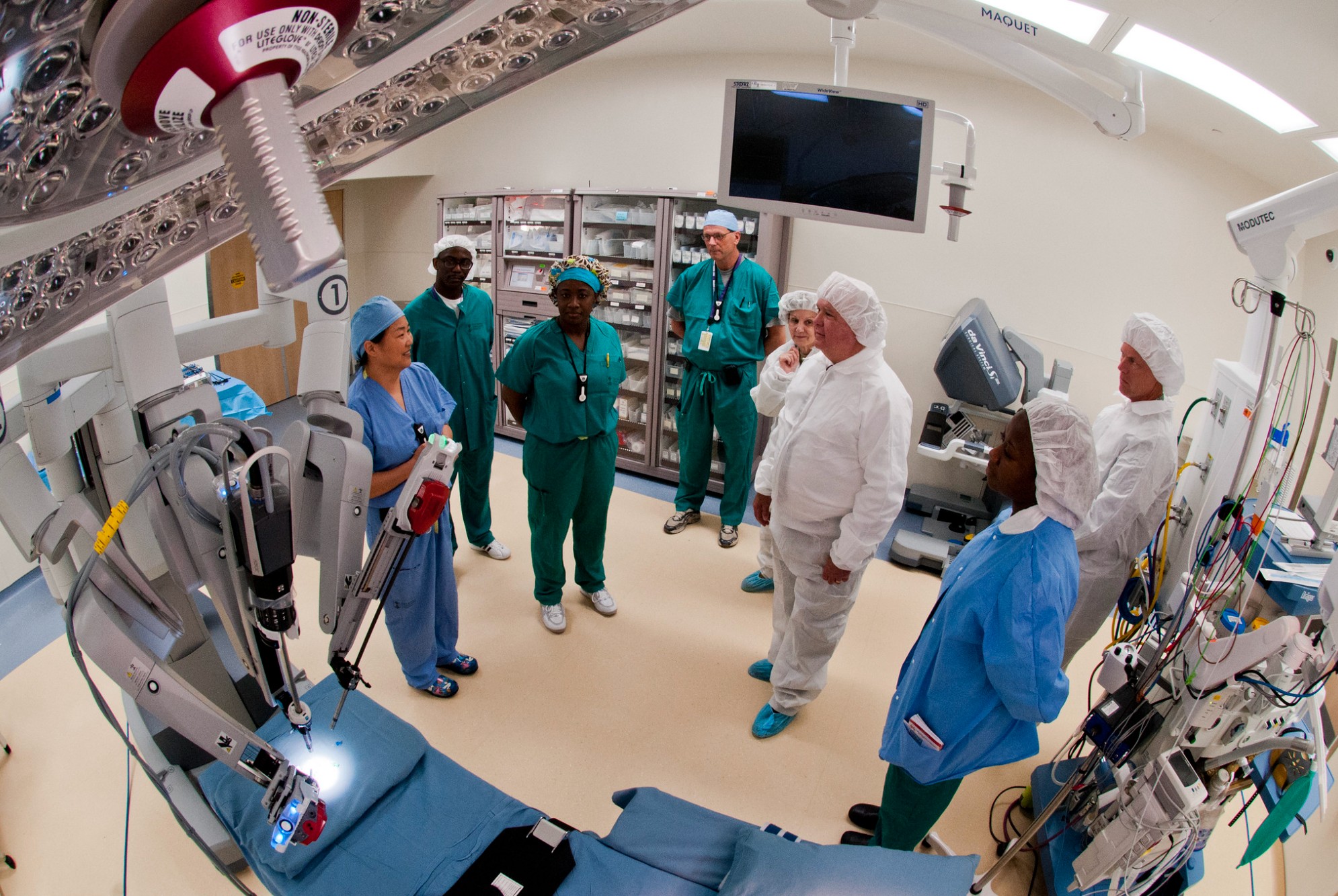 Medical personnel dialog with one another in an operating room.